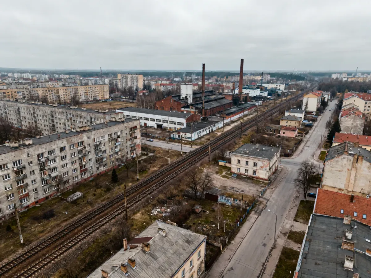 Panorama fikcyjnego polskiego miasta z blokami, dworcem i przemysłową zabudową